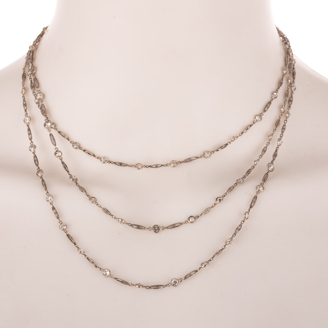 An Art Deco 12.50 ctw Diamond Station Necklace in Platinum: c.1920s, platinum extra long diamond by the yard necklace featuring Old European cut diamonds weighing approx. 12.50 ctw with an average color grade of I - J and an average clarity grade of VS, bezel 