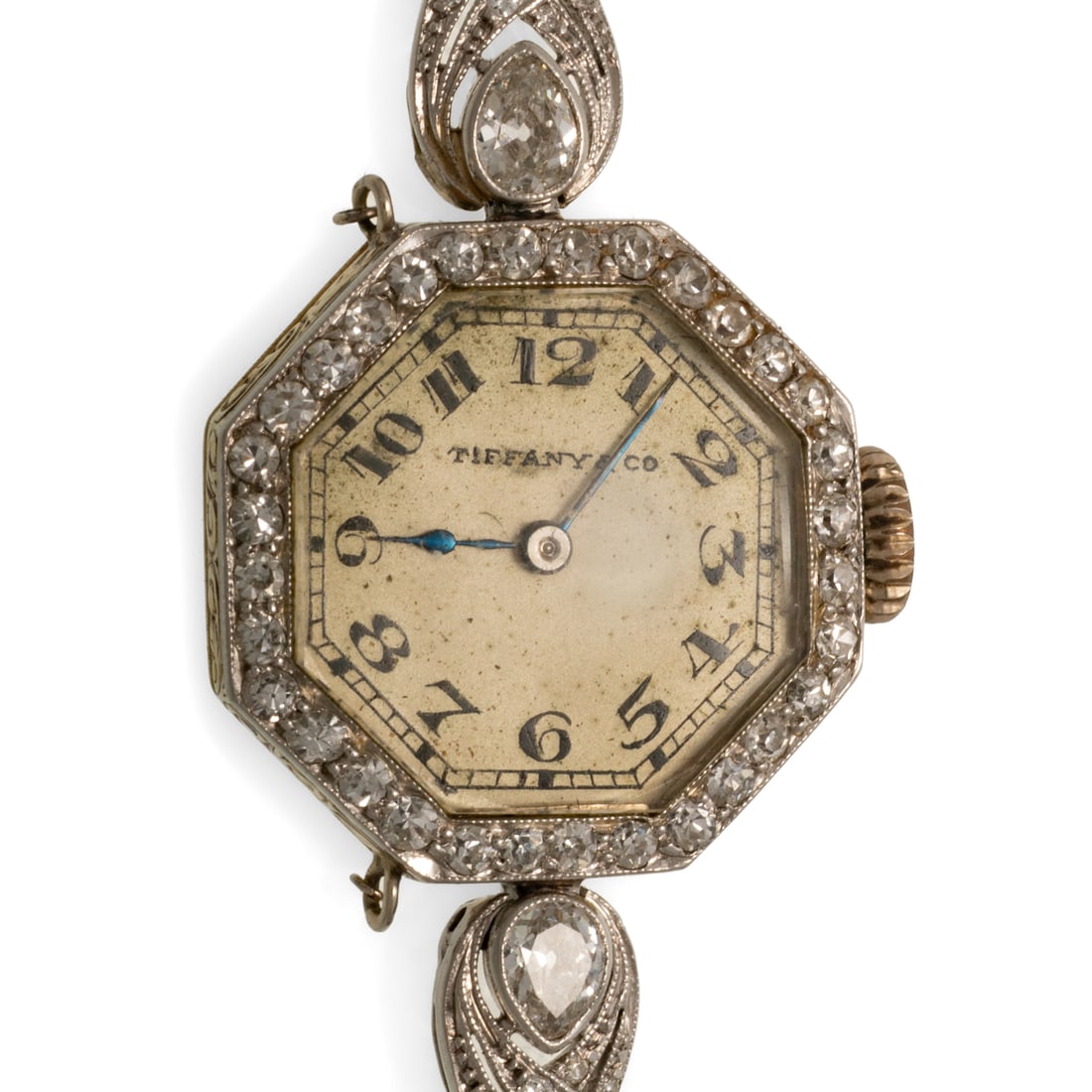 An Early Art Deco Tiffany & Co. Diamond Dress Watch in Platinum: c. 1920s, platinum dress watch by Tiffany & Co., the octagonal dial with Arabic numerals and blue steel hands, bezel and line bracelet with round and pear Old European cut diamonds bead and bezel set 