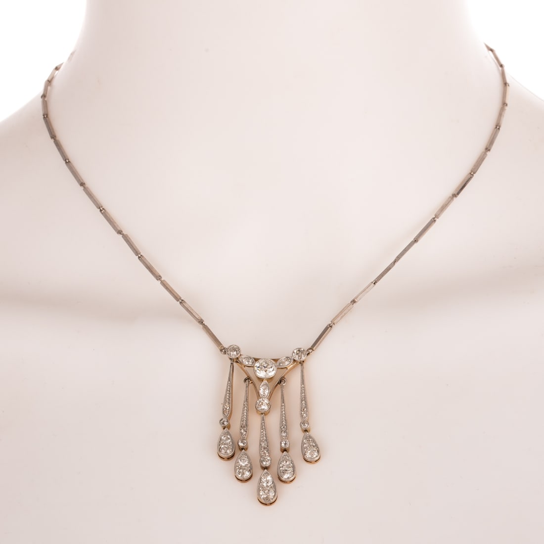 An Art Deco Diamond Lavalier Necklace in Platinum: c.1915s, 18K yellow gold and platinum topped lavalier necklace with articulating fringe dangles Old European cut diamonds weighing approx. 2.20 ctw (largest one weighing approx. 0.70 carats) with an a