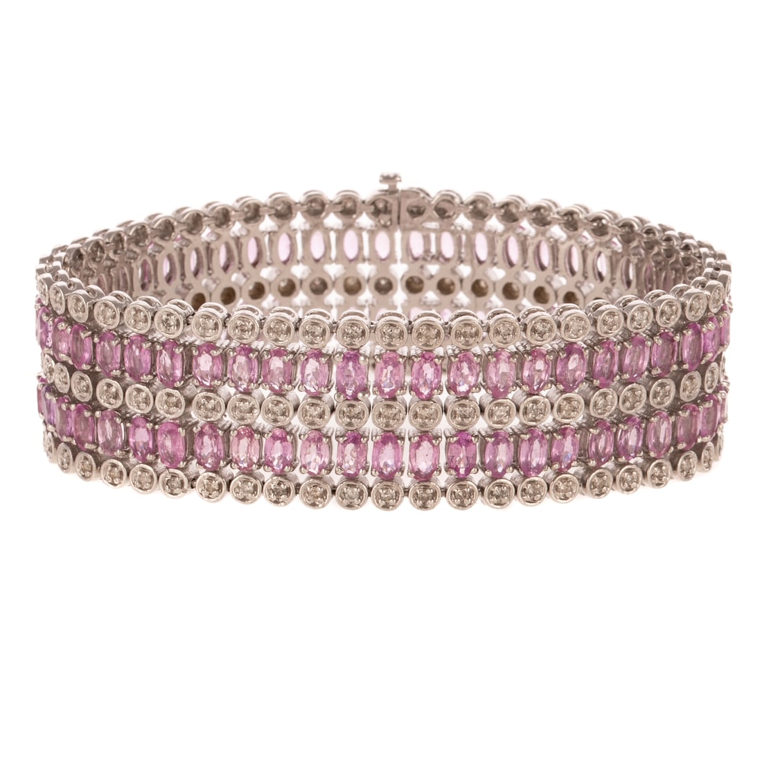 A 25.00 ctw Pink Sapphire & Diamond Bracelet in 14K: 14K white gold wide flexible bracelet featuring well matched oval pink sapphires weighing approx. 25.00 ctw set in two rows with diamonds weighing approx. 3.00 set into circular links, 7/8 in. W, doub