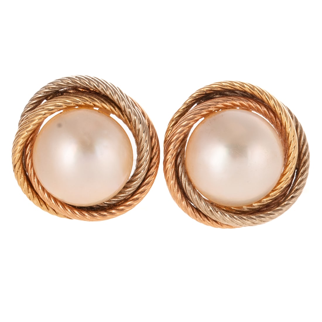 A Pair of Mabe Pearl Ear Clips in 14K: 14K bi-colored gold ear clips featuring white mabe pearls measuring 12.5 mm in the center of a white and yellow twisted frame, one with bent post and one with broken post and clip backs, 3/4 in. Diam.