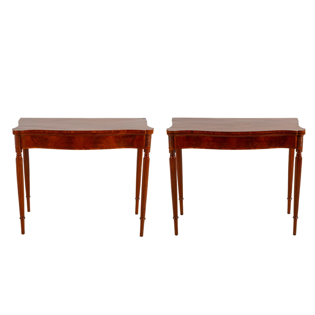 A Pair of Centennial Flip Top Games Tables: In the Massachusetts manner, circa 1875. Shaped flip tops with turret corners, banded inlay and bookended aprons, extended into reeded tapered legs ending in cuffed feet, each: 30 in. H, 36 in. W, 17