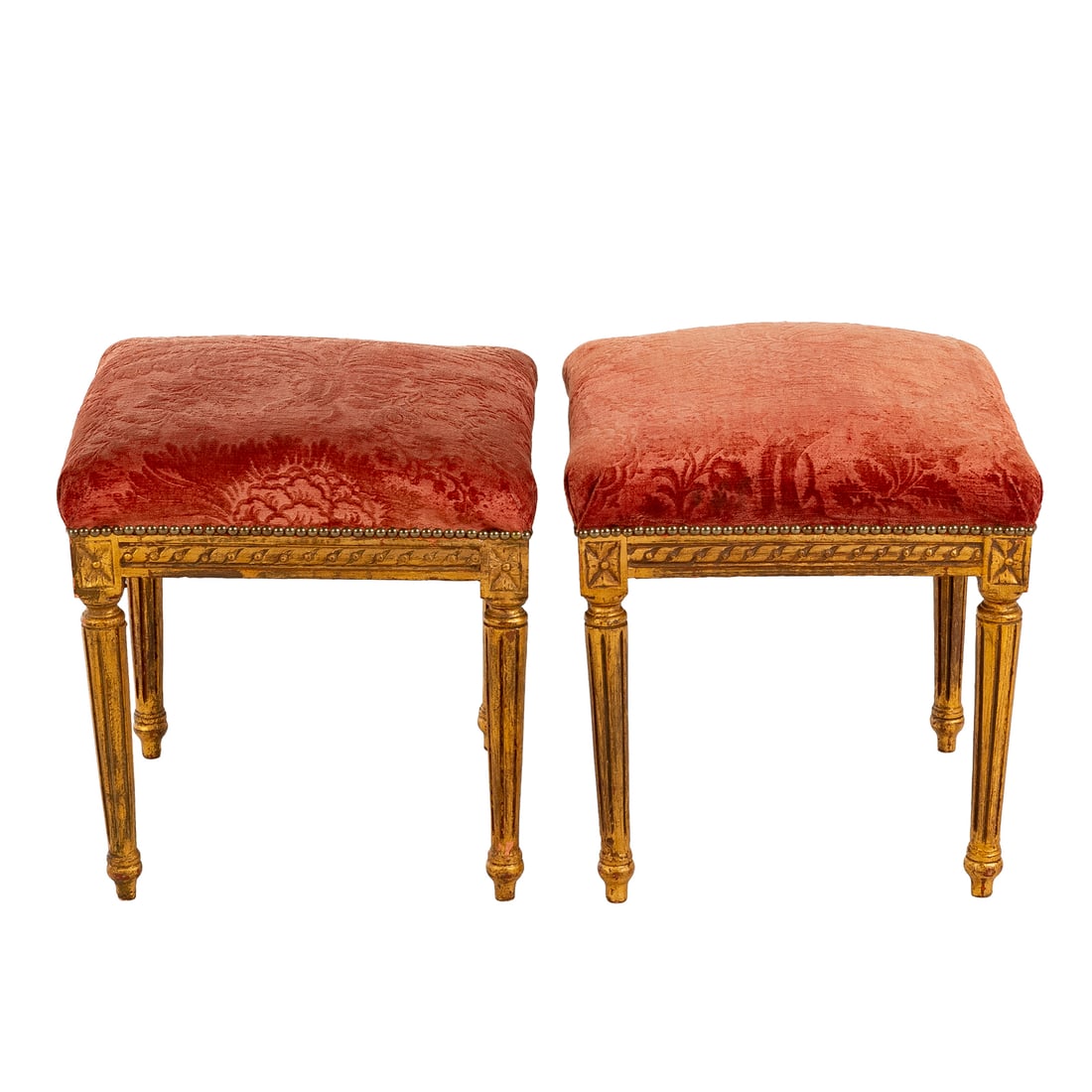 A Pair of Louis XVI Style Upholstered Footrests: Red damask upholstery on carved gilt aprons supported by turned and tapered reeded legs, each: 19 in. H, 18 in. Sq.