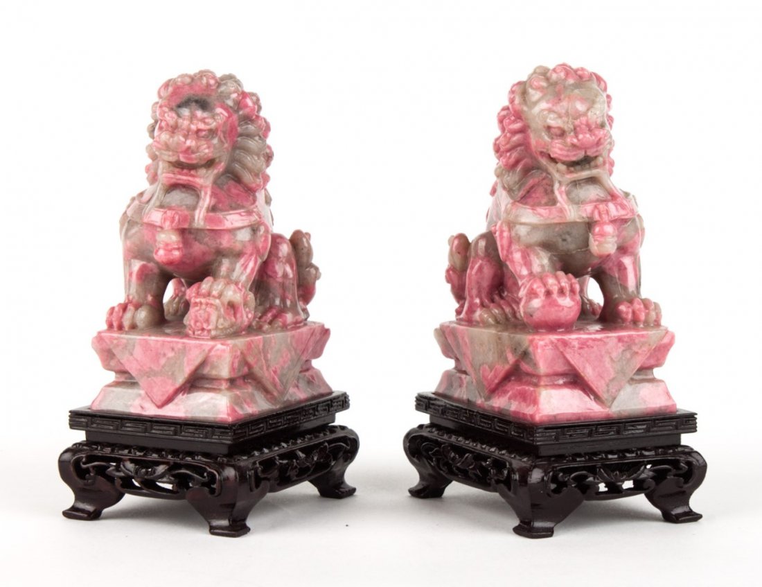 Pair of Chinese carved hardstone foo dogs: possibly rhodochrosite, with oriental wood stands, 3 1/2 in. H.