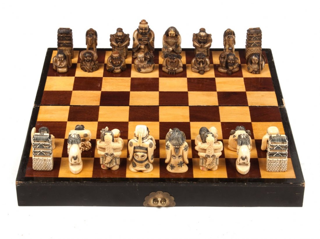 Japanese carved ivory chess set: 32 carved ivory netsuke figures acting as chessmen, 16 stained brown all with ink highlights, figures in the form of deities, beasts, and demons, 3 in. H. of King, board - 18 in. Sq.
