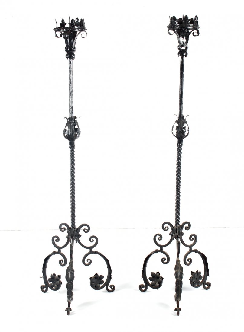 Pair of Neo-Gothic wrought iron candlesticks: first half-20th century; large pricket altar candlesticks with twisted-turned shaft on tripod scroll, and foliated tripod legs, 66 in. H.