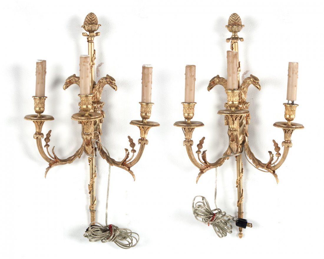 Pair of French Empire style gilt-bronze sconces: with double eagle head decoration, three candle arms with applied grapevine and foliate decoration at top with pine comb finial, 24 in. L.