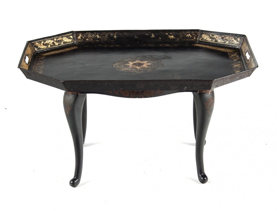 Victorian tole tray table: second half-19th century; ebonized and gilt stencil two-handled tole tray attached to japanned Queen Anne style base, 17 in. H., 32 in. W., 23 in. D.