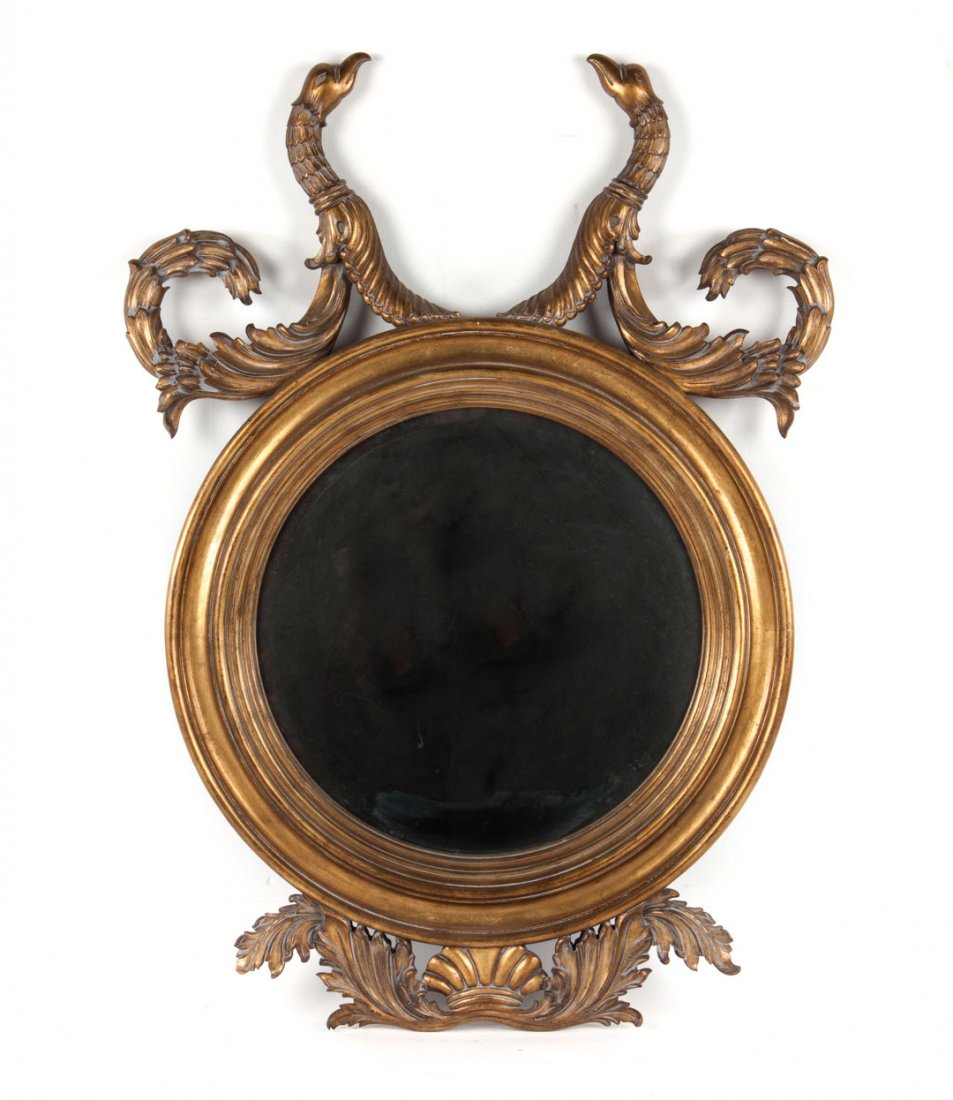 Italian Classical style giltwood mirror: circular frame with double sea serpent cornice and scroll an shell on bottom, 48 in. H., 32 in. W.