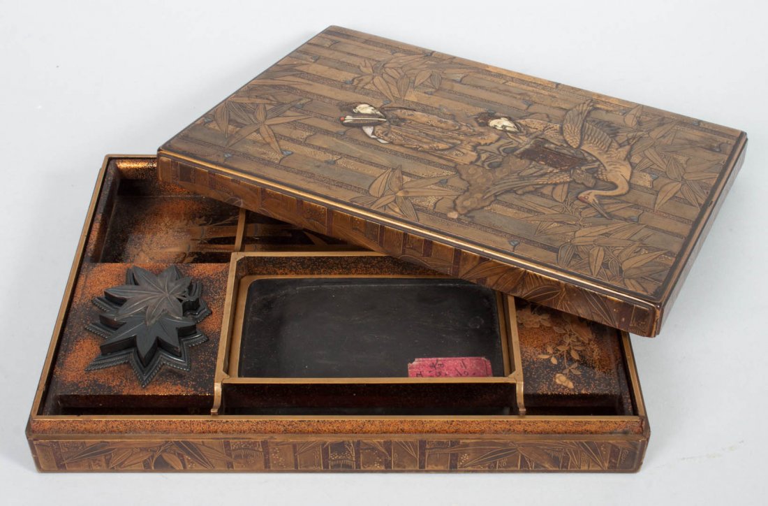 Japanese lacquer scholar's writing box: late 19th century; lid with bamboo and forest relief decoration with two scholars, each with inlaid ivory face, interior with gilt and gold dust bamboo and bird decoration, scholar's ink blot and leaf