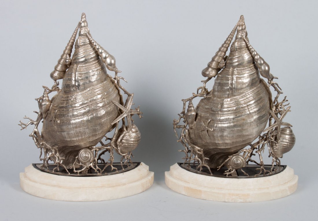 Pair of silvered bronze seashell wall brackets: each modeled as large trumpet shell with coral branches, starfish, and smaller shells, with attached demilune onyx shelf, 16 in. H., 12 in. W.