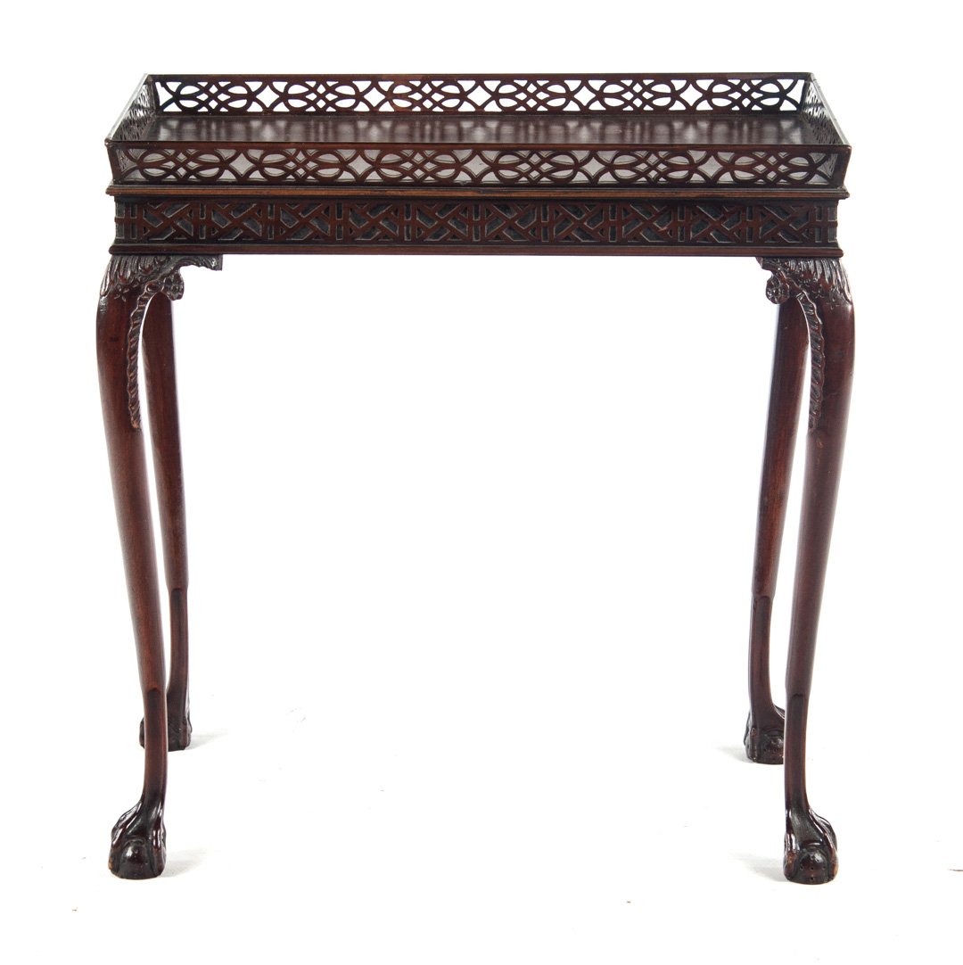 Chippendale style mahogany silver table: 20th century; reticulated wood gallery and carved relief fretwork edge with ball and claw feet, 28 in. H., .27 in. W., 17 in. D.