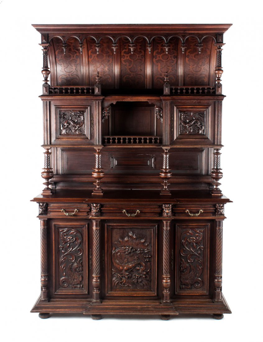 Renaissance Revival walnut buffet a deux corps: Belgian, late 19th century; elaborately carved piece with game, urn, flower, and mask relief decoration, 105 in. H., 64 in. W., 24 in. D.