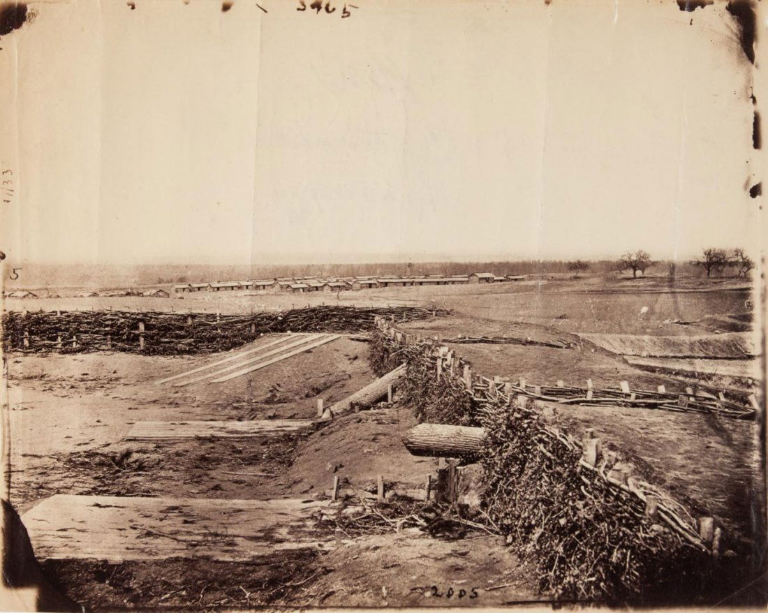 Photograph: "Quaker Guns, Centreville, Va.": showing rough timber breastworks with tree-trunk "guns" and a winter camp in the distance, attributed to Barnard & Gibson, 1862; vintage print, 8 X 10 in.; framed