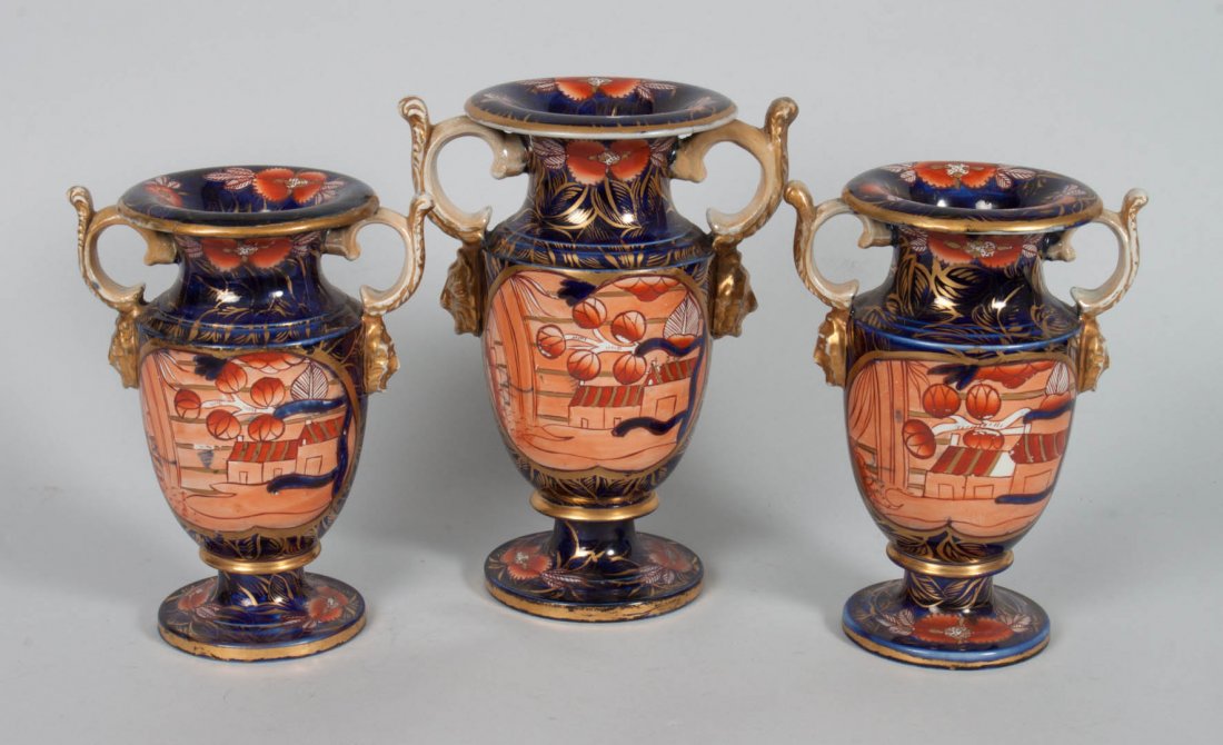 English china three-piece garniture: circa 1825; in the Imari taste, probably Spode, comprising: pair of small urns and matching large urns, 7 1/2 to 9 in. H.