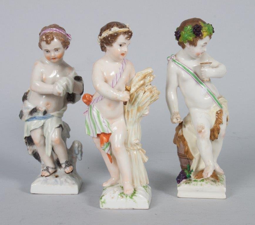 KPM figures of the seasons: early 20th century; each figure modeled as putti with seasonal garb and attributions, including: Winter, Summer, and Autumn, each approx. 6 1/2 in. H.