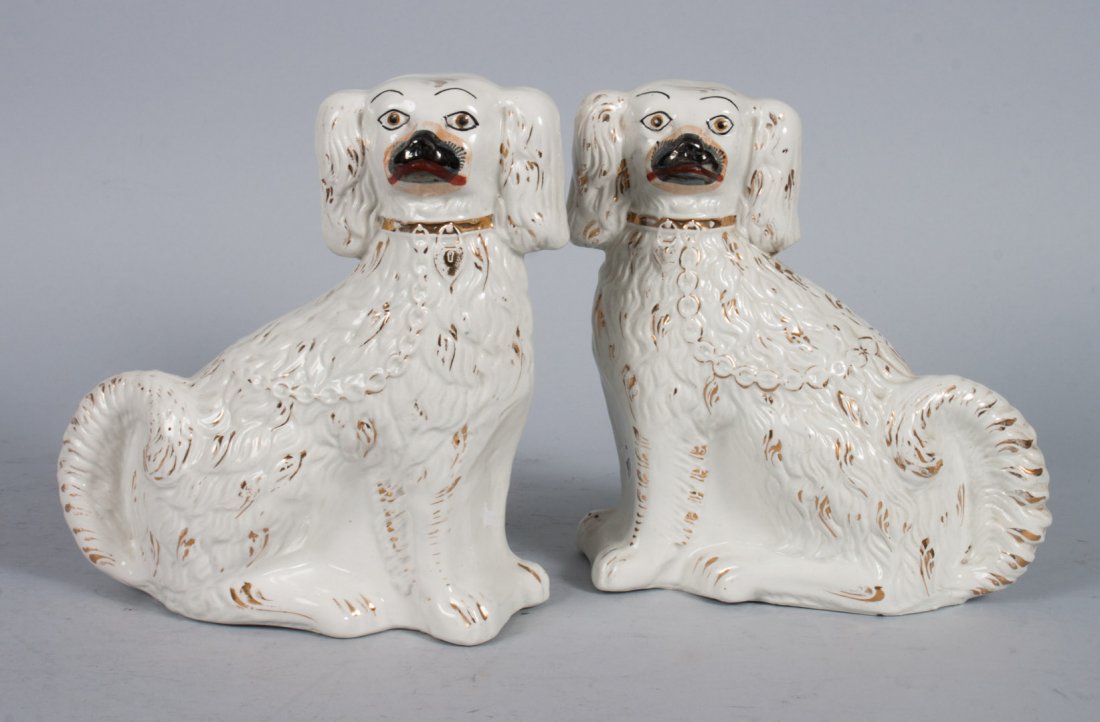 Pair of Staffordshire earthenware spaniels: early 20th century; with paint and parcel-gilt highlights, 8 1/2 in. H.