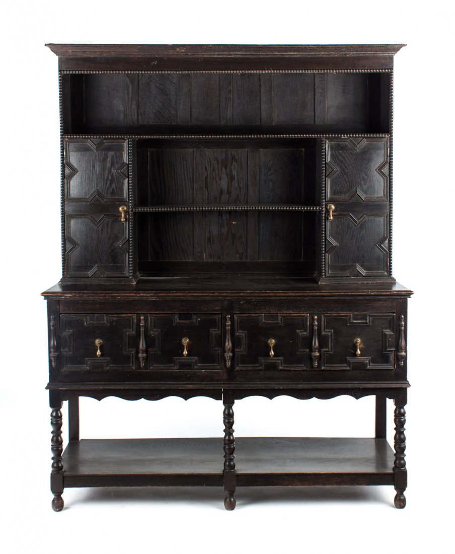 Jacobean style oak Welsh dresser: second half-19th century; top case with two shelves and panel cabinet doors, bottom case with two panel drawers and stretcher shelf, 77 in. H., 60 in. W., 20 in. D.