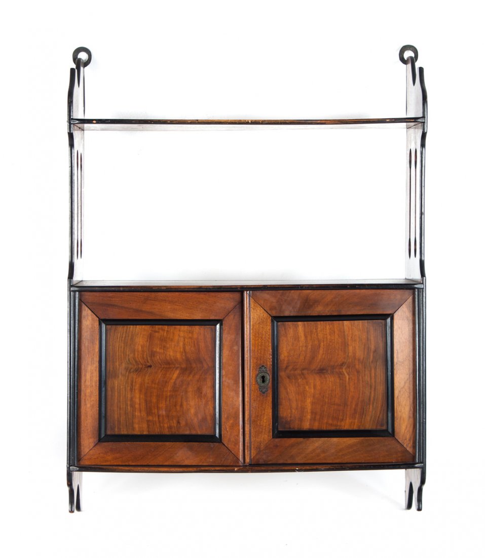 Edwardian carved walnut hanging shelf: late 19th/early 20th century; open shelf with compartment beneath enclosed by double solid panel partial ebonized doors, 15 in. H., 18 1/4 in. W., 7 1/2 in. D.