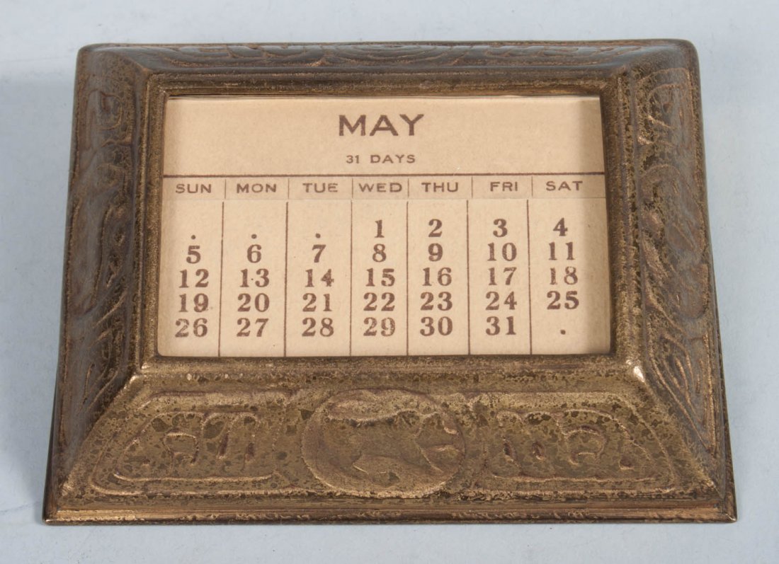 Tiffany gilt bronze desk calendar: first quarter-2oth century; zodiac pattern, with original paper calendar inserts, impressed "Tiffany Studios New York 939," 4 1/2 in. W.