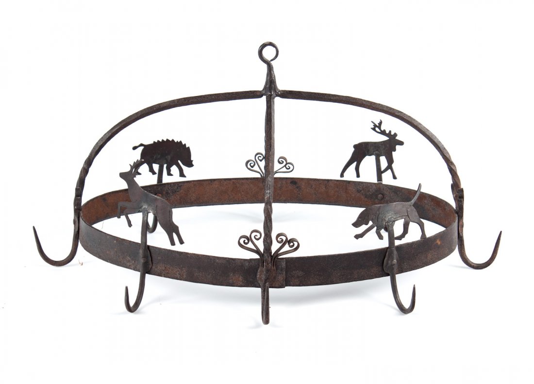 Continental wrought iron hanging pot holder: probably Scandinavian, oval pot holder with eight hanging hooks and animal decoration, including reindeer, hound, and wild boar, 15 in. H., 29 in. L., 20 in. W.