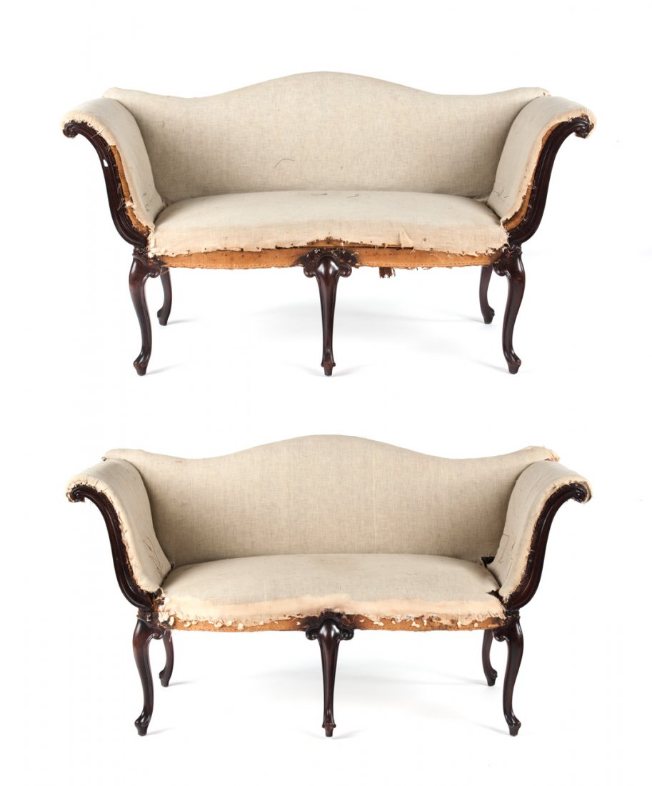 Pair of Italian Rococo style settees: each with curved crest rail, upholstered back, exposed scroll carved upholstered arms and seat over frame, three cabriole front legs and double back legs, muslin under upholstery, 32 1/2 in. H., 58 in