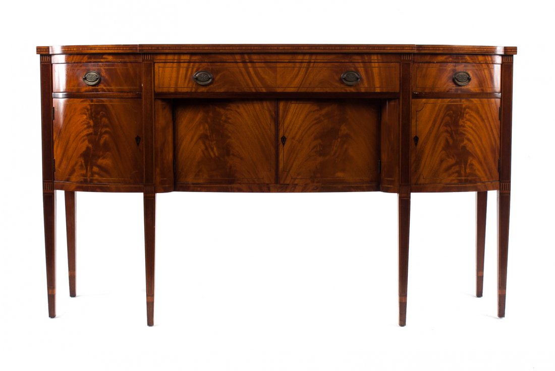 Federal style inlaid mahogany sideboard: one long and two short stringer inlaid drawers, center compartment beneath enclosed by inlaid panel doors with solid panel doors on each side, straight tapered legs with stringer inlay, 38 in. H., 66 