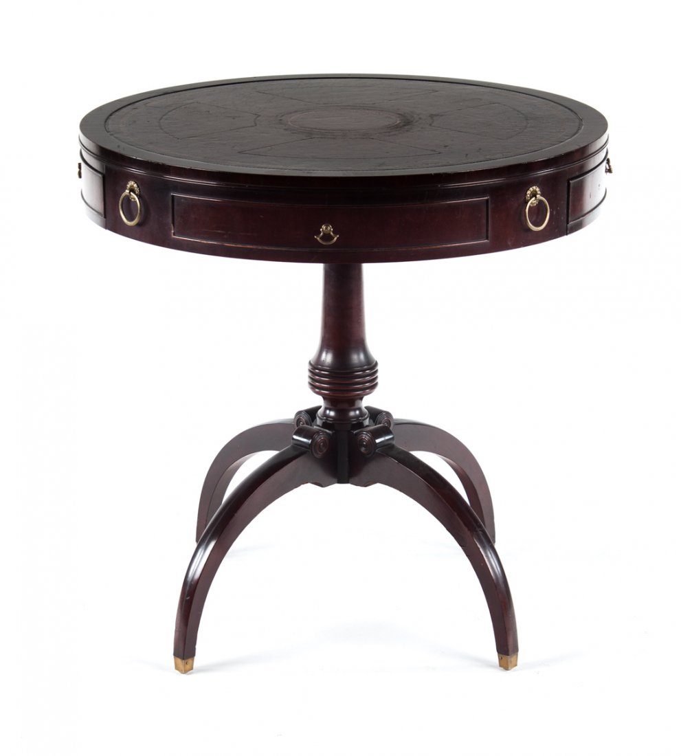 Regency style carved mahogany drum table: 30 in. tooled leather inset, round top with two bowed drawers in 3 3/4 in. apron, round-turned standard on four incurvate splayed legs, 30 1/4 in. H.