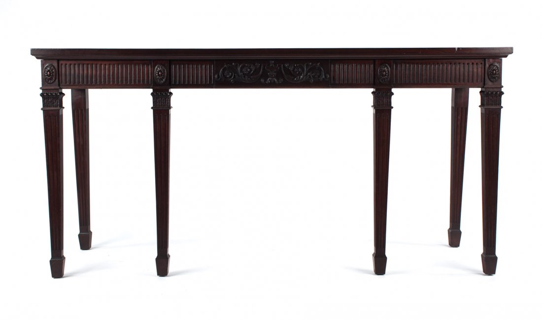 George III style carved mahogany sideboard: late 19th/early 20th century; flat top, foliate carved and fluted 4 1/2 in. frieze, six straight tapered and fluted legs with spade feet, 35 in. H., 72 in W., 22 1/2 in. D.