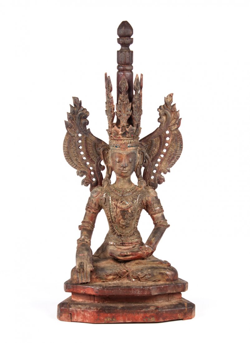 Thai Shan style figure of the Buddha: seated, one hand touching the earth; carved wood, painted, with traces of gilding, applied mirror chips, 38 in. H.