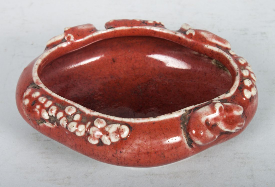 Chinese porcelain scholar's water dipper: 19th century or earlier; ovoid shape with applied floral and scroll decoration, ink mark characters underneath, 5 in. L., 4 in. W.