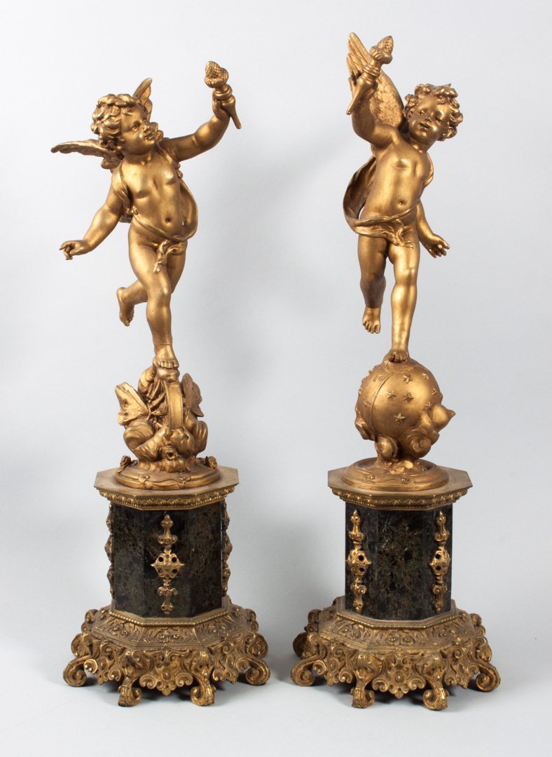 E. Bruchon. Pair of spelter sculptures: Emile Bruchon (French, 19th c.). "Amour Vagabond," each modeled as torch-holding cherub, one standing on starred globe, the other on the Wheel of Destiny, with octagonal marble center column, base wit