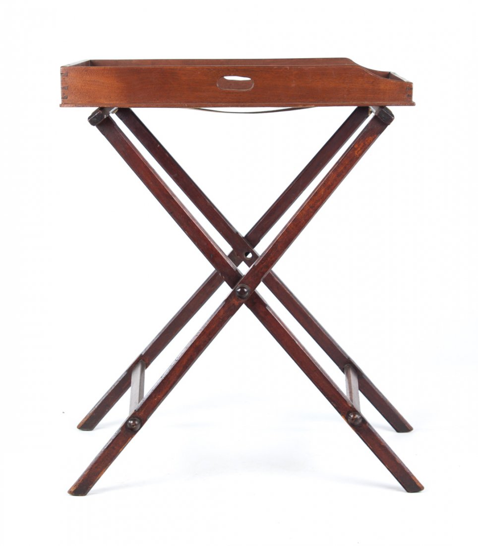 English vernacular walnut butler's tray on stand: 19th century; tray has 3 in. raised gallery with slotted lift handles, stand with fabric straps, 27 1/4 in. W., 17 3/4 in. D.