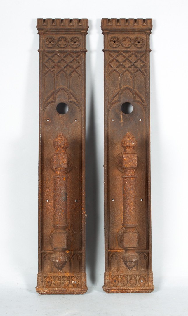 Pair of Victorian Gothic ecclesiastical door pulls: late 19th century; plates with battlement style tops and molded relief Gothic arch decoration, supporting large pull handles, 26 in. L.