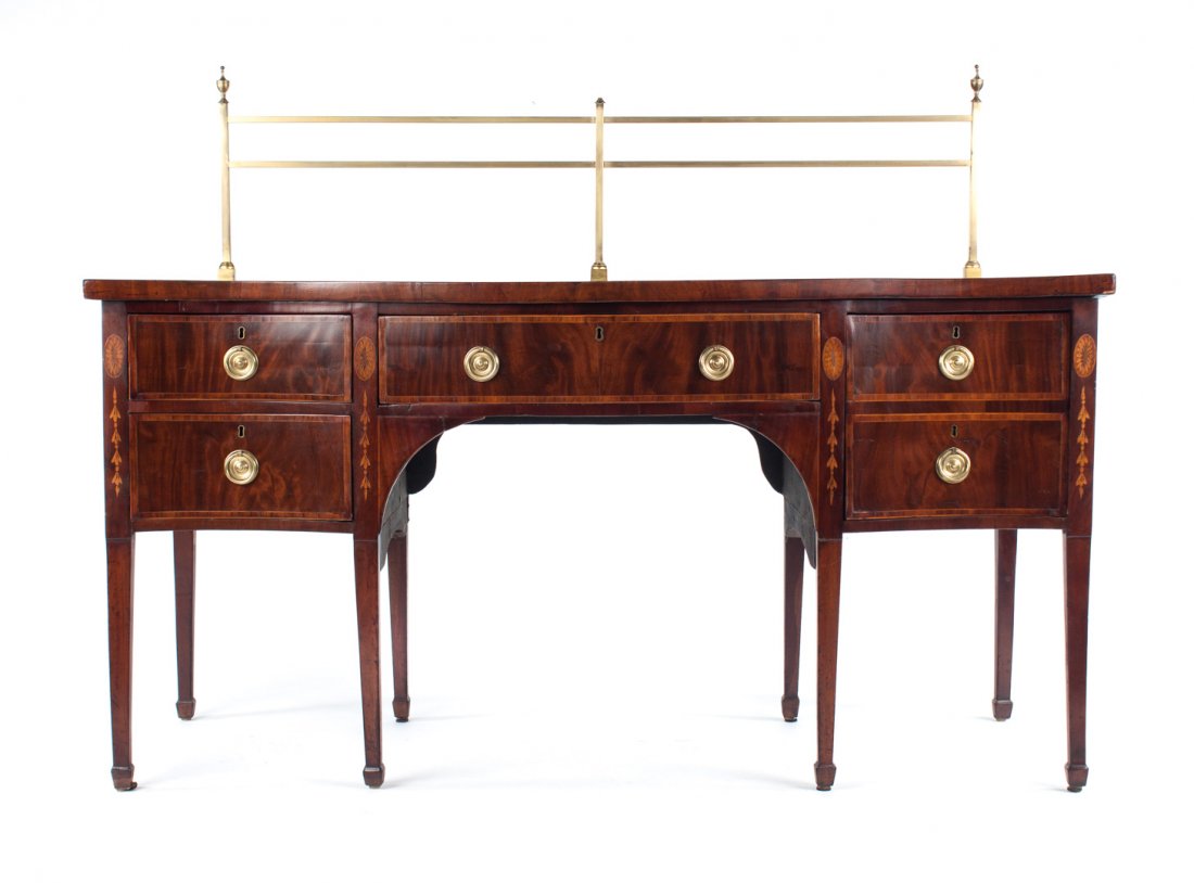 George III inlaid mahogany serpentine sideboard: circa 1800; brass gallery, single drawer flanked by cabinet door and two short drawers, straight tapered legs ending in spade feet, with elaborate bellflower and patera inlays, 52 in. H., 70 in. L., 2