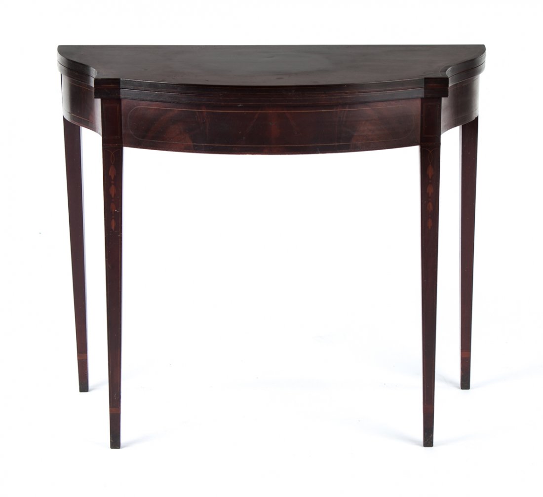 Federal style mahogany flip-top games table: early 20th century; in the Baltimore manner, bellflower and stringer inlays, shaped front, square tapered legs, 30 in. H., 36 in. W., 18 in. D.