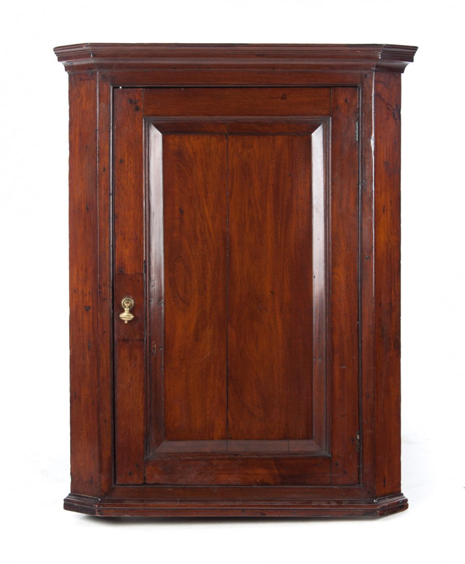 George III mahogany hanging corner cupboard: late 18th/early 19th century; flat molded cornice, compartment with shaped shelves enclosed by solid panel door, molded base, 42 in. H., 31 in. W., 17 1/2 in. D.