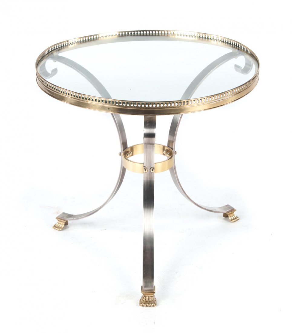 Contemporary brass and chrome coffee table: 23 1/2 in. round glass top with pierced brass gallery, three scrolled chrome legs with brass animal paw feet, 22 1/2 in. H.