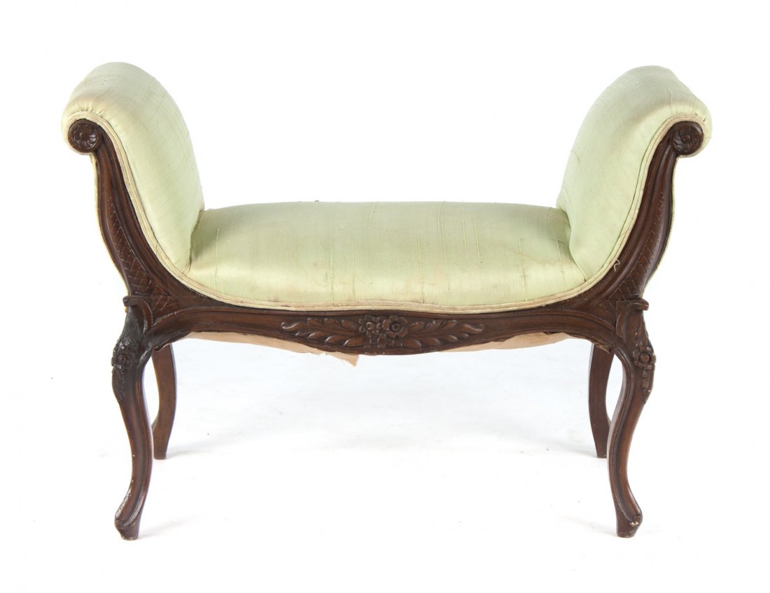 Louis XV style carved walnut window seat: upholstered arms and seat over floral carved exposed frame with cabriole legs, 25 in. H., 36 in. W., 17 in. D.