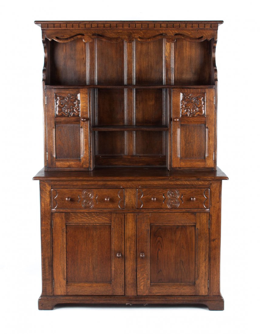 Tudor Revival oak Welsh cupboard: flat top with shaped openworked cornice, open shelves and double animal carved solid panel doors in upper section, base has two medium drawers with cupboards beneath enclosed by solid panel doors, 71 