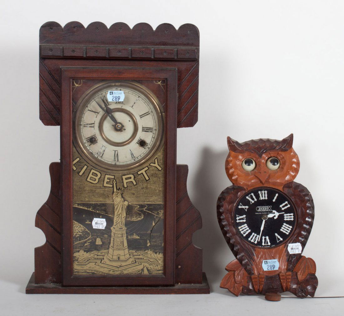 "Liberty" mantel clock & owl moving-eye clock: Victorian kitchen clock with gold stenciled image of Ellis Island and in large letters "Liberty," and a carved wood owl clock with moving eyes