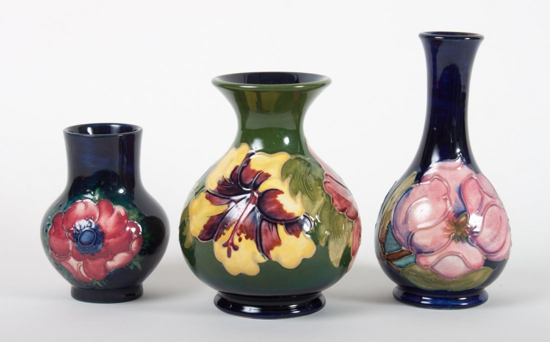 Three Moorcroft art pottery cabinet vases: first half-20th century; each with floral decoration, impressed mark, 4 to 6 in. H.