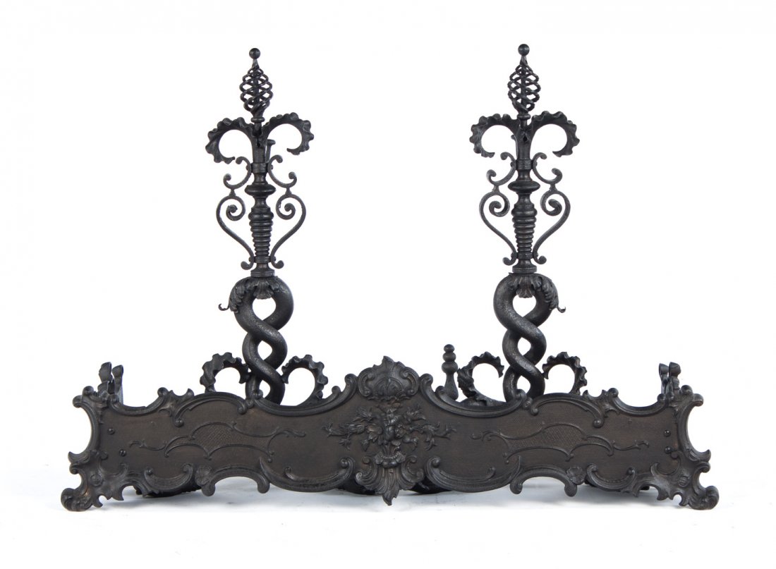 Pair of Art Nouveau cast iron andirons and fender: early 20th century; andirons modeled as entwined serpents, 29 in. H., solid relief cast three-part fender, 10 in. H., 39 in. W.