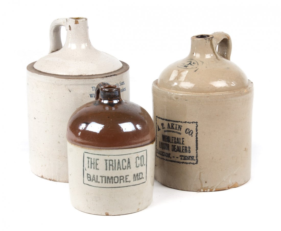 Three American stoneware advertising jugs: late 19th/early 20th century; brown and white jug, "The Triaca Co. Baltimore, MD.," 10 in. H.; white stoneware jug, stamped "Thomas Pepper's Sons, Wholesale Liquor Dealers, Ashland, PA.," 13 in. H.; s