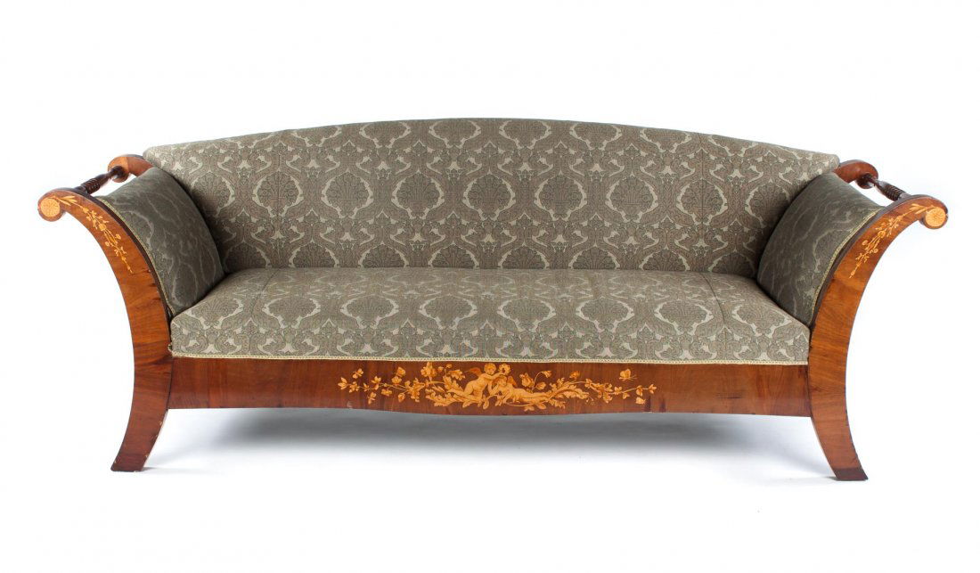 Biedermeier style walnut upholstered sofa: 19th century; curved upholstered back, arms, and seat over half frame, scrolled arms with exposed facings and rolling pin termini, arms and apron with inlaid putti and foliated design, 36 in. H., 96 i