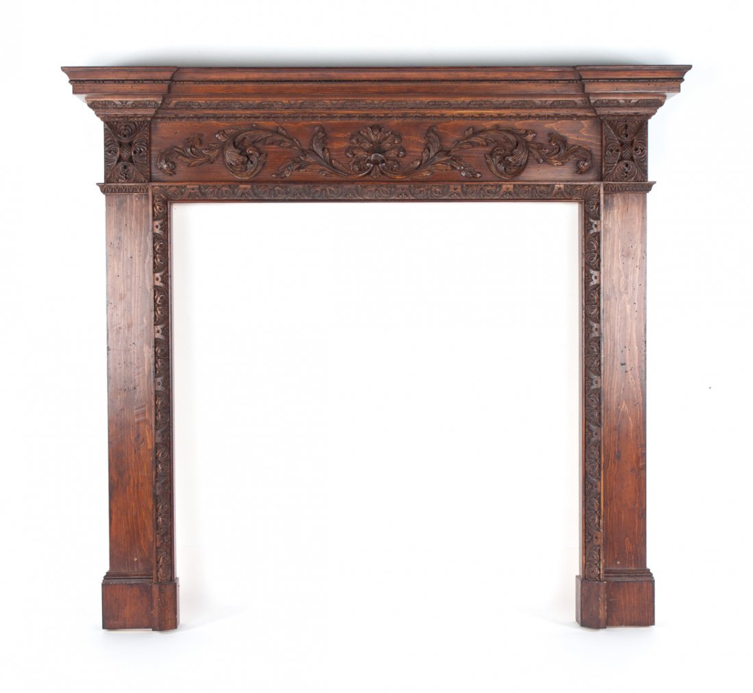 George III style carved pine mantel: 20th century; flat molded cornice, 6 in. frieze with applied foliate carving, 59 1/2 in. H., 64 1/2 in. W., 10 in. D.