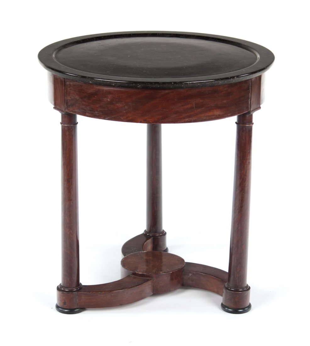 French Empire marble top mahogany gueridon: early 19th century; 26 in. round variegated black marble top with molded rim, short drawer in 3 3/4 in. apron, three columnar legs connected by stretcher base, 27 1/2 in. H.
