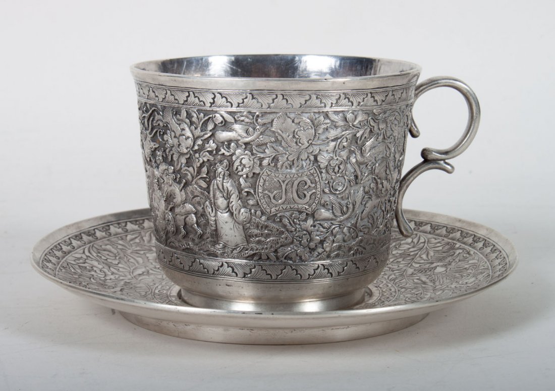 Chinese repousse silver cup & saucer: maker unidentified, late 19th century; the cup with repousse monogram "JC," 3 in. H., the saucer with chased design to match the cup, 5 7/8 in. Diam.; 10.15 ozt.