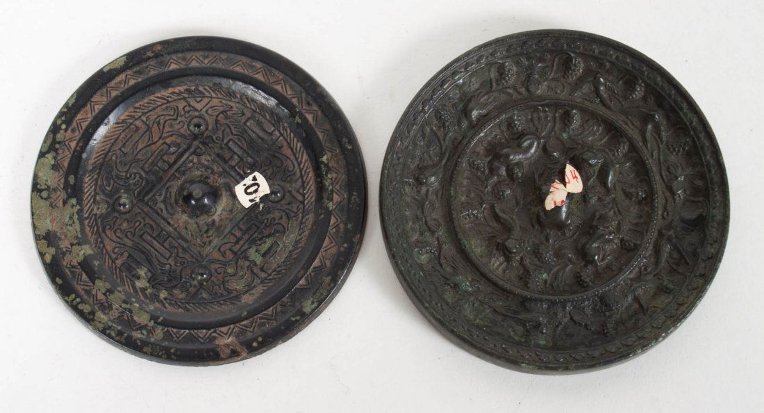 Two Chinese archaic bronze hand mirrors: Sung or earlier; each circular mirror with relief decoration on back, each 3 1/2 in. Diam.