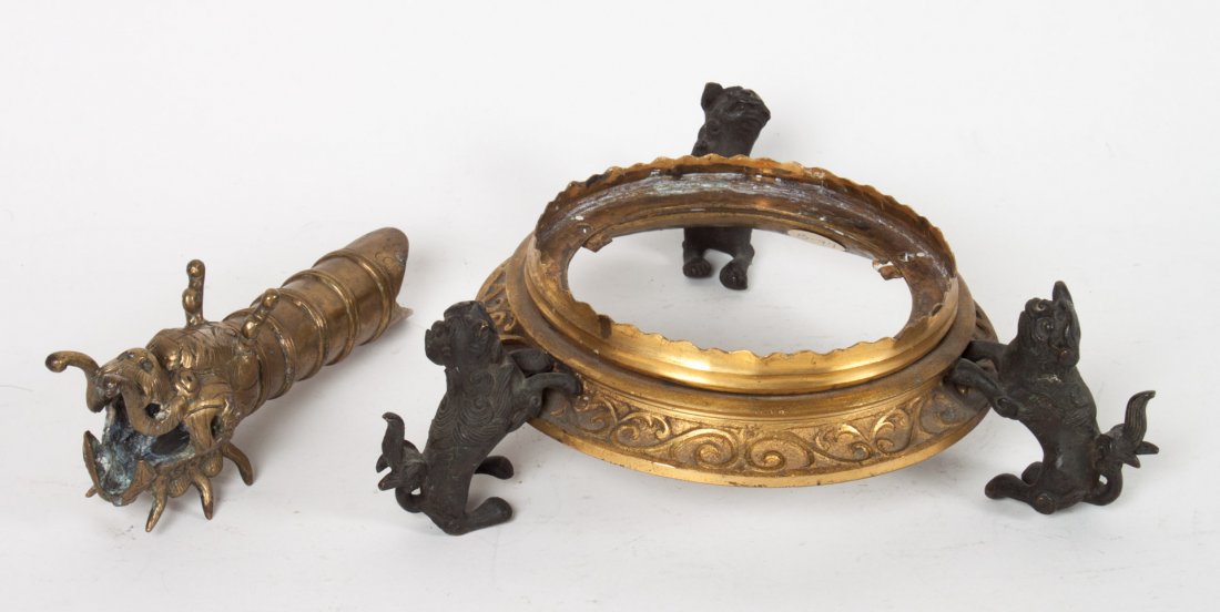 Chinese gilt and patinated bronze lamp base: 20th century; circular gilt bronze base supported by three patinated bronze foo dogs, 2 1/2 in. H., 6 in. Diam., and a Chinese brass dragon-form handle, 6 in. L.
